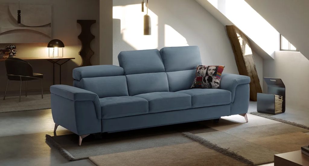 Divano lineare blu in zona living con luce naturale, punto focale della zona giorno