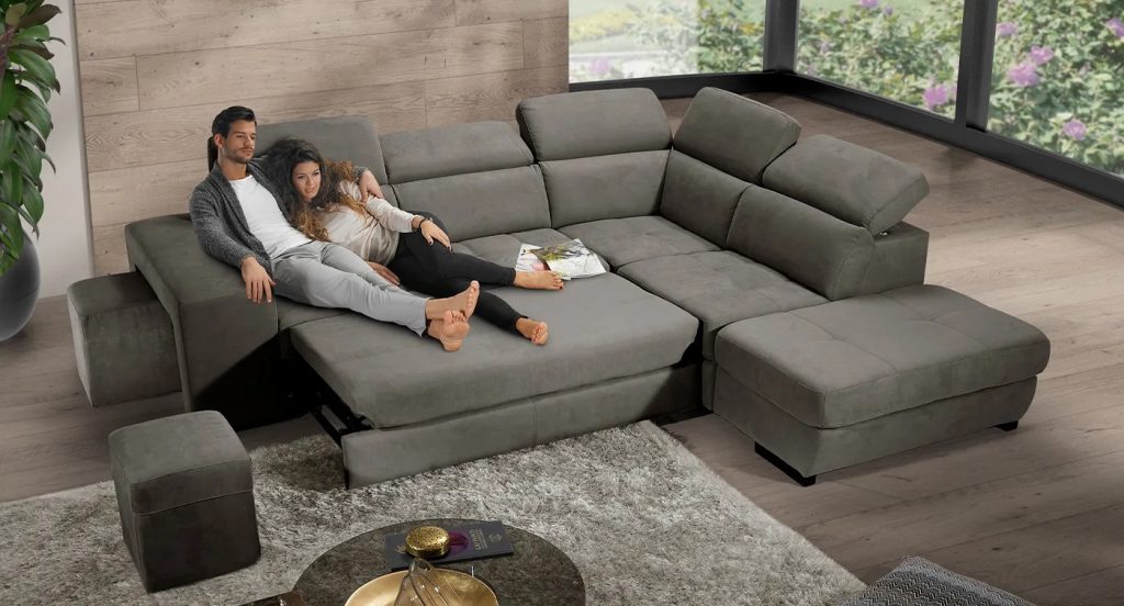 Grande divano grigio antracite angolare con seduta relax in open space contemporaneo