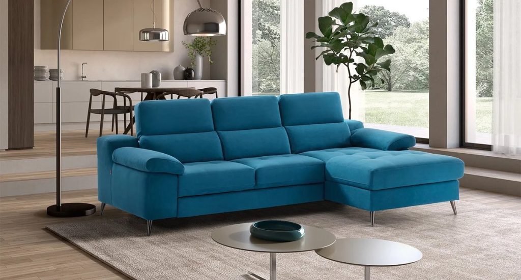 Soggiorno con tavolo e divano con chaise longue in ambiente open space luminoso