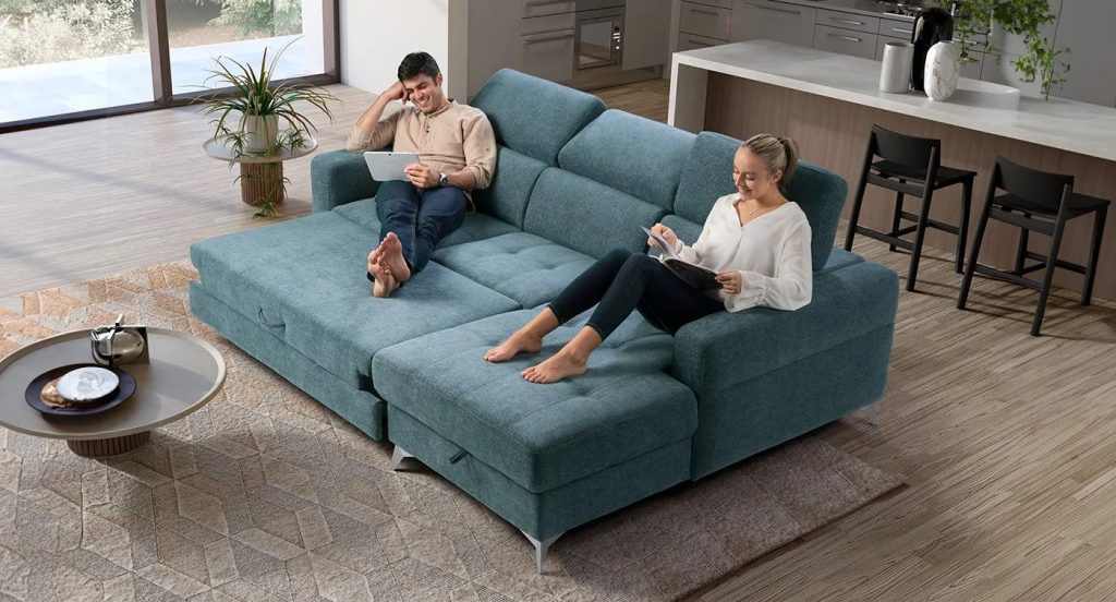 Divano moderno inserito accanto alla sala da pranzo per definire una confortevole zona relax.