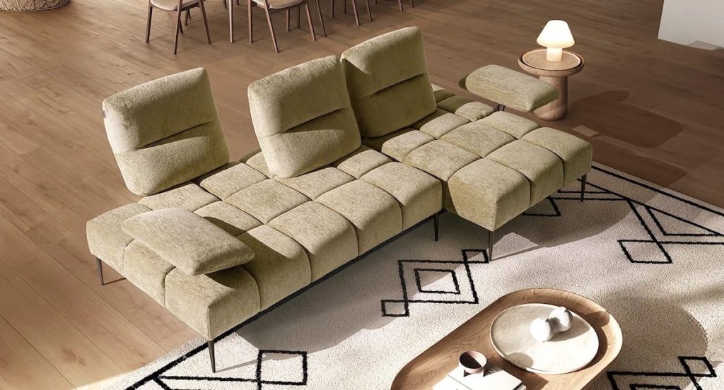 Divano moderno con tavolino laterale e lampada da appoggio per creare un angolo accogliente.