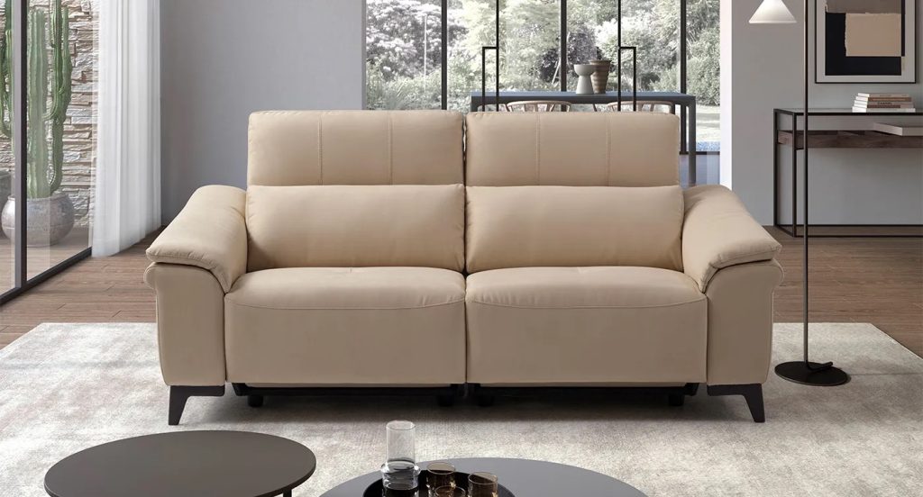 Divano in pelle chiara con sedute reclinabili in ambiente contemporaneo